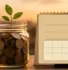 Retirement savings jar and blank planning calendar representing Required Minimum Distributions and retirement deadlines